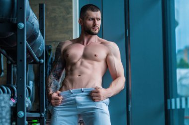 Motivated male athlete does exercise, bodybuilding workout at gym. Strong muscular man has fitness workout. Sport and healthy lifestyle concept. Muscular man workout in gym doing exercises with