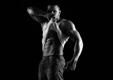 Altı paket. Erkek striptiz. Çıplak gövde. Kaslı adam karın kaslarını gösteriyor. Yakışıklı adam poz veriyor. Sportif, sağlıklı, güçlü kaslı adam. Üstsüz model.