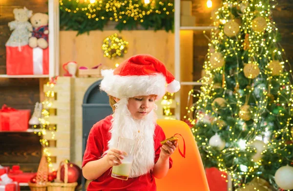 Santa Claus takes a cookie on Christmas Eve as a thank you gift for leaving presents. Christmas food and drink. Christmas child