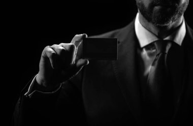 Kredi kartı sahibi bir iş adamı. Elinde boş bir kredi kartı modeli var. Kredi kartı el ele tutuşmanın şablonunu oluşturur. Banka kartı. Ticari marka