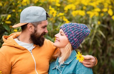 Yakışıklı sakallı, modaya uygun kazak ya da kazak giyen kaygısız genç kadın. Merhaba Autumn. Doğada poz veren romantik sonbahar çifti