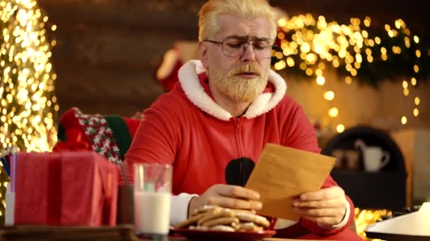 Забавный Санта Читает Список Желаний Против Дома Рождественской Елкой — стоковое видео