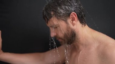 Adam banyoda saç yıkıyor. Küvette banyo yapan adam. Yüzü duşta köpüklü. Banyo yapan adam duş alıyor. Yakından duş alan adam. Duş konsepti. İnsan duşta su altındadır.