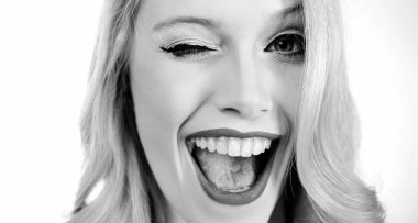 Çekici makyajlı ve göz kırpan beyaz arka planda genç ve güzel seksi bir kadının portresi.