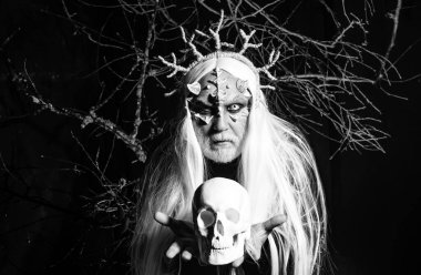 Kafatası olan boynuzlu şeytan, eski usul. Büyüde gücüm var. Yüzünde dikenleri olan gizemli bir savaşçı. Sihir ve masal kavramı. Ağaç ruhu ve fantezi konsepti. Kötü vampir adam.