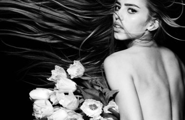Uzun saçlı seksi güzel kadın lale çiçeği tutuyor. Güzellik salonu