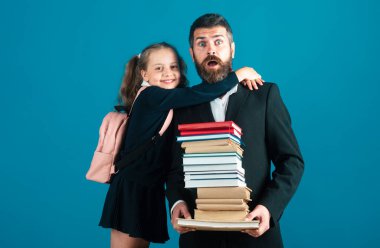 Stüdyoda ilköğretim öğrencisi kucaklaşması öğretmeni. Baba ya da öğretmen ve liseli kız büyük yığınlar halinde okul kitaplarına sahipler. Öğretmenler Günü