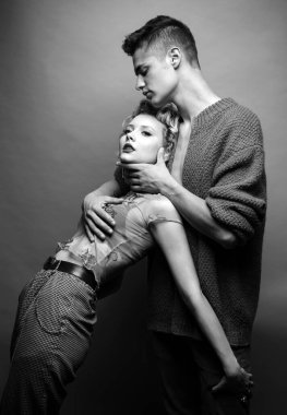 Fotoğraf çekilirken sevgi dolu bir çift. Rahat ol. Genç bir çiftin hassas bir fotoğrafı. Güzel bir çiftin moda stüdyosu fotoğrafı. Sevgililer Günü. Duygusallık. Gri renkte izole edilmiş