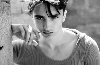 Genç bir adamın yakın portresi. Yakışıklı erkek suratı. Erkeklerin cinselliği, çekiciliği ve karizması, erkek güzelliği kavramı