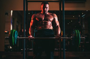 Kaslı adam yaya geçidinde. Halter kaldıran kaslı adam. Crossfit spor salonunda çalışan genç bir adam. Sporcu adam egzersiz yapıyor.