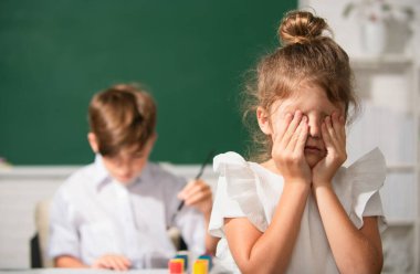 Zeki bir liseli kız ağlar. Okul üniformalı kız koluyla yüzünü örterek okulda karatahtanın önünde zorbalığa uğradığı için üzülüyor. Çocukluk ve eğitim sorunları kavramı