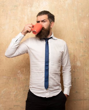 Yakışıklı adam elinde bir fincan kahve tutuyor. Sabah çayı. İyi sabahlar. Çay fincanlı adam. Bir fincan kahveli hippi adam. Sakallı adam gülümsüyor, elinde bardak çayı var. Uyan! Uyan! Mutlu bir gün. Sabah çayından sonra