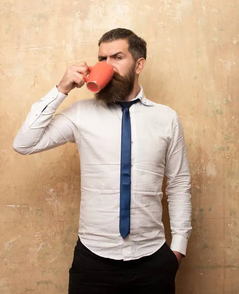 Yakışıklı adam elinde bir fincan kahve tutuyor. Sabah çayı. İyi sabahlar. Çay fincanlı adam. Bir fincan kahveli hippi adam. Sakallı adam gülümsüyor, elinde bardak çayı var. Uyan! Uyan! Mutlu bir gün. Sabah çayından sonra