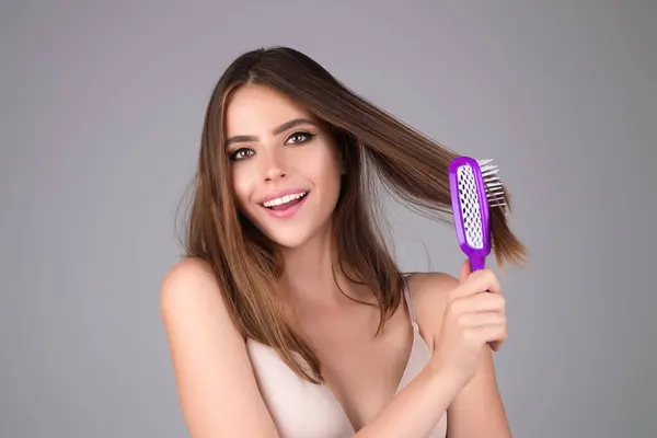 Young woman taking care with hair comb of her hair. Haircare. Pretty girl brushing hairs with comb. Beauty, hair loss products, shampoo and hair care concept