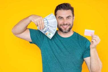 Başarılı bir iş adamı para sayıyor. Yakışıklı orta yaşlı adam 100 dolarlık banknotları tutuyor. Elinde para tutan adam. Kâr ve finansal başarı. Dolar nakiti olan zengin bir adam.