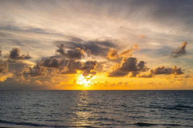 Sunset sea landscape. Colorful beach sunrise with calm waves. Nature sea sky. Tropical beach seascape horizon. Sunrise with clouds of different colors against the blue sky and sea