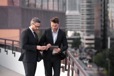 Takım elbiseli işadamlarının dışarıda kredi kartı ve laptop tabletleri var. Hesabı öde. Şehirde kredi kartı olan bir adam. İş anlaşması. Ticaret sözleşmesi ve yeni projeler. Başarı işi