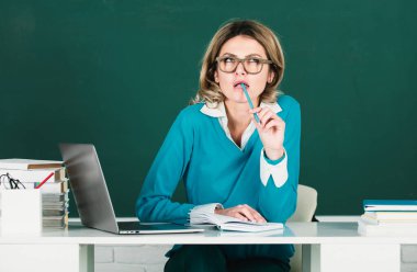 Modern çekici öğretmen. Lisede ya da kolajda tahtaya kitap yapıştırılmış, gözlüklü zeki genç bir kadının portresi. Üniversitede kız öğrenci eğitimi. Eğitim, okul ve insanlar