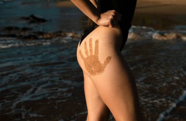 Sexy summer woman butt. Girl buttocks in swimsuit. Summer beach. Sandy woman buttocks on the hawaii beach background. Sexy summer woman body. Vacation at Paradise. Ocean beach. Relax and travel