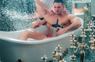 Banyodaki seksi çift. Adam şarapla banyo yapıyor. Aşıkların ilişkileri