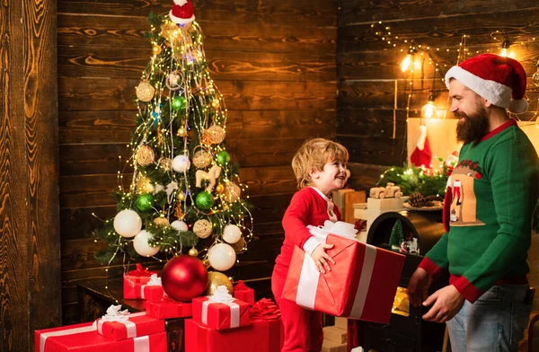 可爱的小儿子与父亲庆祝圣诞节 圣诞家庭 父子俩带着圣诞礼物在木制房子的背景下 — 图库照片