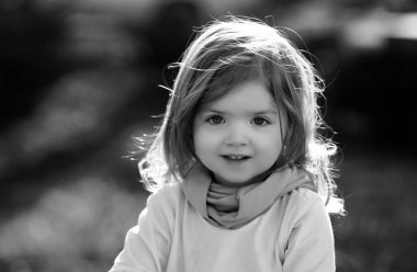 Yaz parkında yeşil çimlerin üzerinde bir bebek. Bebek yüzü yakın plan. Komik küçük çocuk, yakın plan portre. Sarışın çocuk, gülümseyen duygusal yüz.