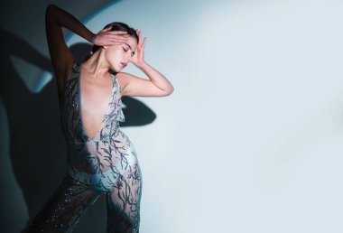Stüdyoda zarif bir kadının yüksek moda portresi. Moda mankeni, güzel genç bir kadın. Vogue elbisesiyle poz veriyor. Stüdyo fotoğrafı.