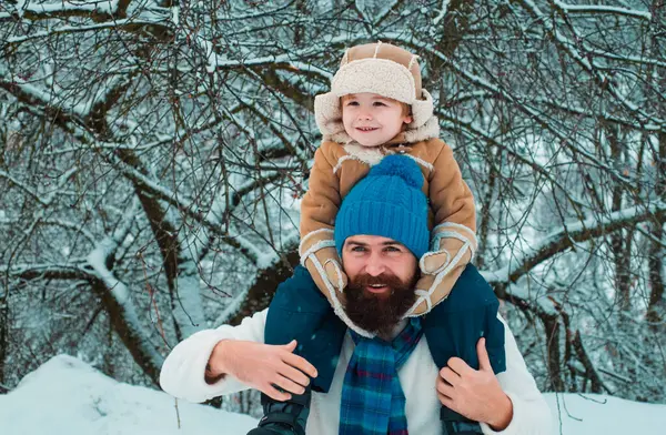 父は息子を公園に戻す 子供は父親の肩の上に座る クリスマス休暇と父と息子と冬の新年 — ストック写真
