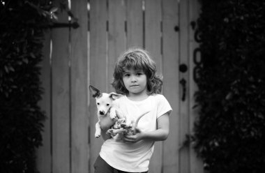 Yavrular ve çocuklar dışarıda. Küçük çocuk küçük bir köpek taşıyor, hassas duygular.