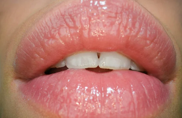 Closeup female mouth with soft pink natural lips and white clean perfect healthy teeth. Sensual forms of woman lips