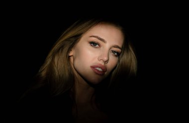 Siyah stüdyoda gölgeli, güzel yüzlü seksi bir kadın. Karanlıkta güzel bir kadın yüzü