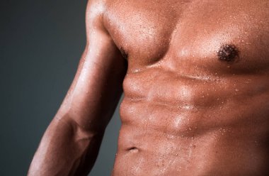 Atletik adam kaslarını kasıyor. Karın kasları, karın kasları, karın kasları. Seksi ve çıplak kaslı genç adam.