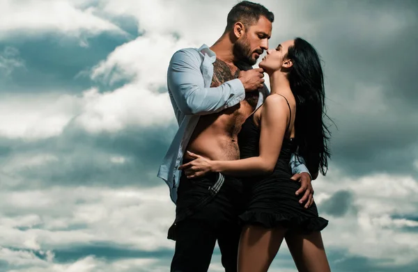 Sevgi dolu insanlar, birbirine aşık sevimli bir çift. Seksi kız ve çıplak gövdeli kaslı erkek arkadaşı açık havada öpüşüyor.