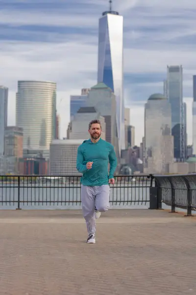 ニューヨークで開催されるスポーツ衣装の男ランナー 健全な走り マンハッタンのダウンタウンの近くを走る成熟したジョギング マッサージアスリートスポーツマンが市内を走る スポーツウェアを走る ハンサムな男ランニングワークアウト屋外 — ストック写真
