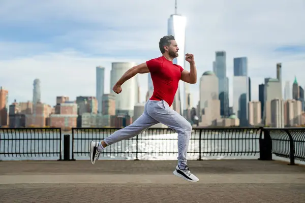 屋外で走る 通りでジョギングする男 成熟した男ランナーとフィットネススポーツモデルは ニューヨークのマンハッタンの近くで屋外でトレーニングします ミレニアムアスリートジョギング 屋外スポーツトレーニング — ストック写真