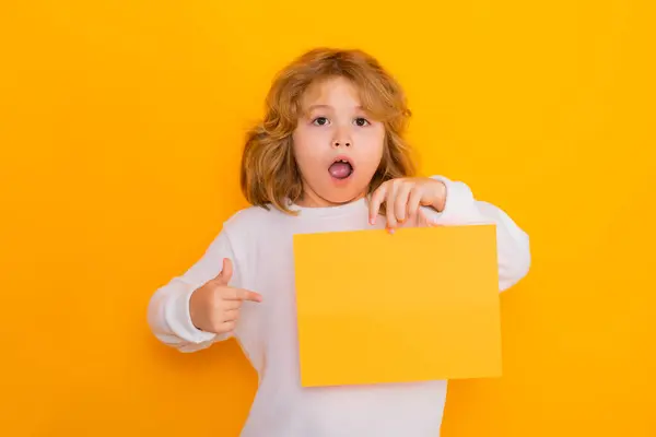 Surprised Kid Boy Showing Index Finger Sheet Paper Isolated Yellow — Stock Photo, Image