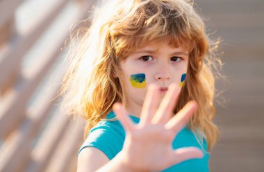 Savaş el hareketlerini durdurun. Çocukların yanağında Ukrayna bayrağı. Ukrayna bayrağıyla protesto eden küçük bir çocuk. Çocuklar protesto ediyor. Çocuklar protesto ediyor