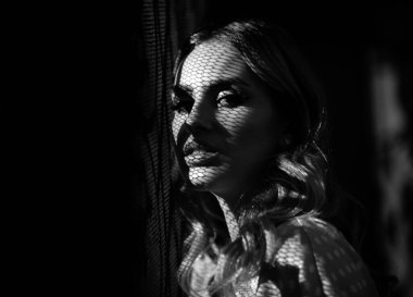 Gölgede kalmış bir kadın. Genç ve şık bir kadının yüzünü kapatın. Güzel, modaya uygun, açık hava portresi