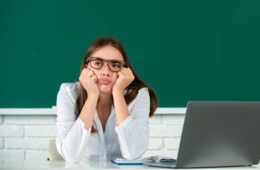 Sınav hazırlayan ve okulda ders öğrenen öğrenci. Üzgün, ciddi ve ilgili bir öğrenci kız.