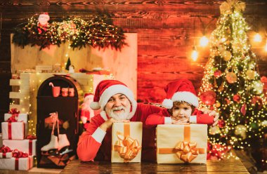 Hediyeleriyle komik küçük Noel Baba yardımcısı. Hediye dolu çanta taşıyan Noel Baba yardımcısı. Noel Baba 'yla tanışmak istiyorum. Noel çocuk Noel 'i evde kutluyor.