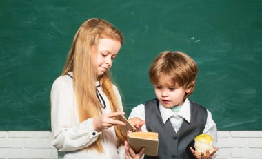 Okula ve mutlu zamanlara geri dönelim. Önce eğitim. Liseli kız, sınıfta masabaşında okuyan öğrencilere yardım ediyor. Öğretmen Schoolgirl okulda sınıfta ödevleri ile çocuklara yardım