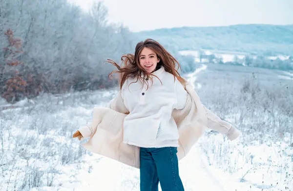 Carefree winter break. Happy moment in winter day. Activity smiling girl playing with snow and having. Happy jumping girl in winter park. Merry Christmas and happy holidays