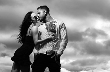 İnsanları sevmek, aşıkların aşkı hissetmesi. Gömleksiz kaslı adam öpüşen kız arkadaşını kucaklıyor.