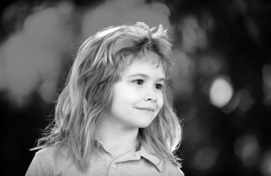 Açık havada gülümseyen sevimli çocuğun yakın portresi. Sarışın çocuk. Doğada gülümseyen küçük bir çocuğun portresi, mutlu küçük anaokulu çocuğu.