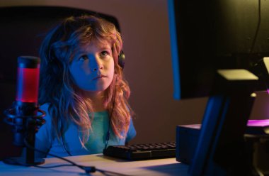 Geceleri bilgisayar kullanan bir çocuk. Karanlık bir odada bilgisayarı olan bir çocuk. Çocuklar için sosyal ağ