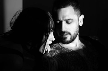 Bir çift genç aşık. Çekici bir çift ve stüdyo arka planında çıplak kaslı bir adam. Birbirine aşık bir çift. Güzel genç aşıklar