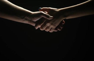 İki ortak arasında tokalaşma. Kurtarmak ya da el hareketlerine yardım etmek. Kurtuluş kavramı. Kurtarma sırasında iki kişinin elleri, anlaşma, yardım. Siyah arkaplanda izole