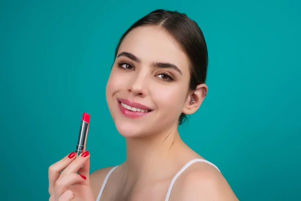 Photo of shirtless woman posing with lipstick, isolated studio background. Beautiful woman holding with naked shoulder hold lipstick. Sexy girl using lipstick
