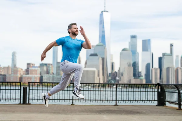ランナー 通りでジョギングする男 成熟した男ランナーとフィットネススポーツモデルは ニューヨークのマンハッタンの近くで屋外でトレーニングします アウトドアスポーツトレーニングをしながら ミレニアルアスリートのジョギング — ストック写真