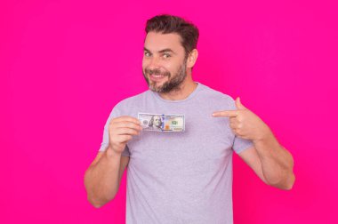 Çekici bir iş adamı para sayıyor. 100 dolarlık banknotlar tutan yakışıklı orta yaşlı bir adam. Parası olan başarılı bir iş adamı. Kâr ve finansal başarı. Dolar nakiti olan zengin bir adam.